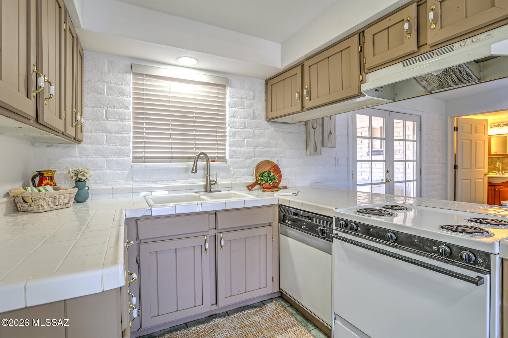 4400 West Ina Road Tucson, AZ 85741 - Photo 6 of 43 a kitchen with cabinets appliances a sink and a window