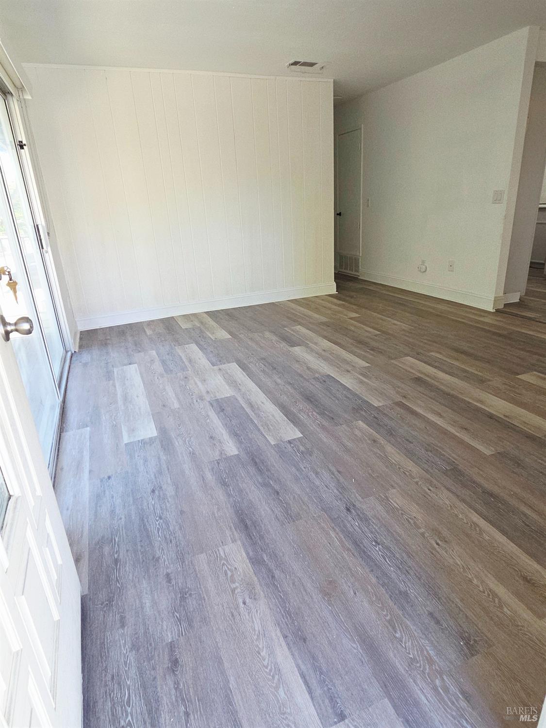 140 Del Rio Court, Unit 4 Vacaville, CA 95687 - Photo 6 of 25 a view of an empty room with wooden floor and a window