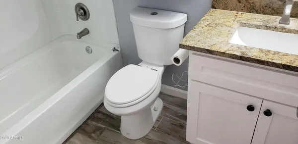 a white toilet sitting next to a bath tub