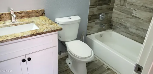 a white toilet sitting next to a bath tub