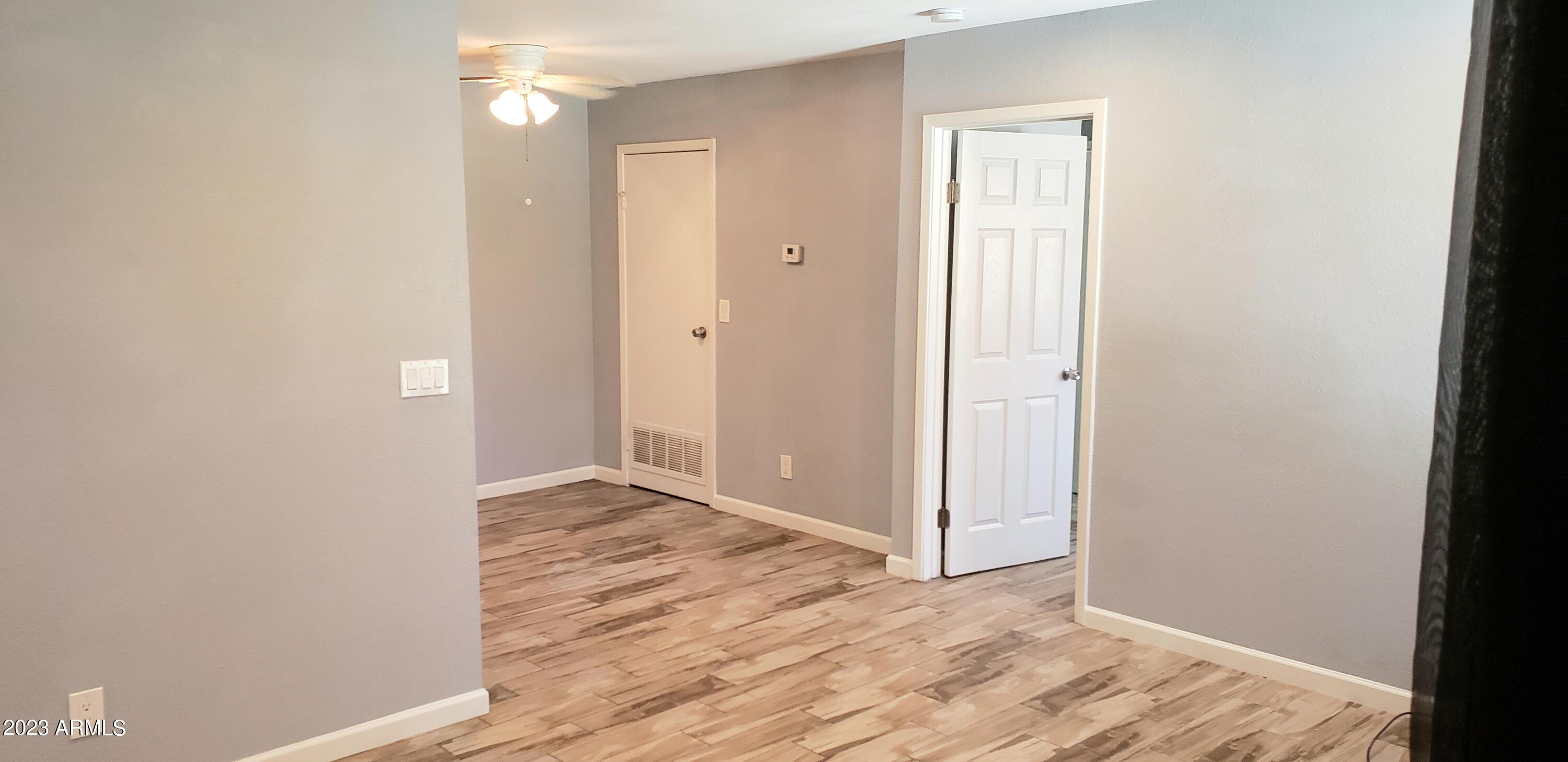 3511 East Baseline Road, Unit 1057 Phoenix, AZ 85042 - Photo 3 of 30 a view of an empty room with wooden floor