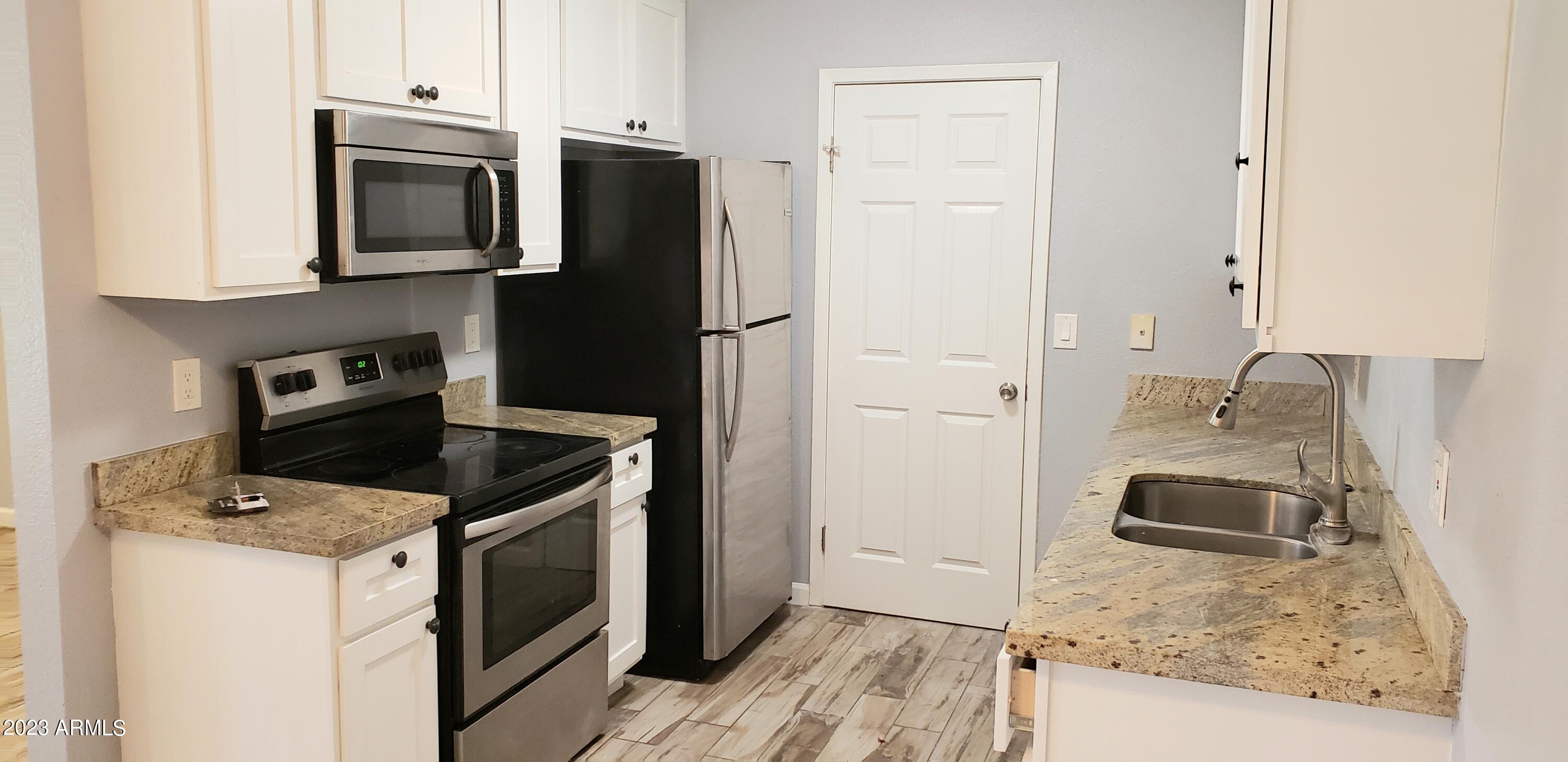 3511 East Baseline Road, Unit 1057 Phoenix, AZ 85042 - Photo 8 of 30 a kitchen with granite countertop a sink stove and refrigerator