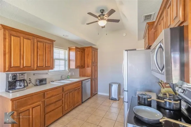 a bathroom with double vanity sink a mirror a toilet and a window