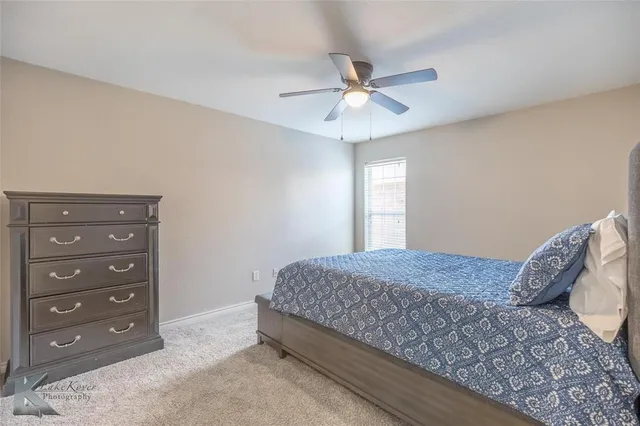 a bedroom with a bed and a chandelier fan