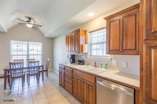 a kitchen with a table chairs sink and cabinets