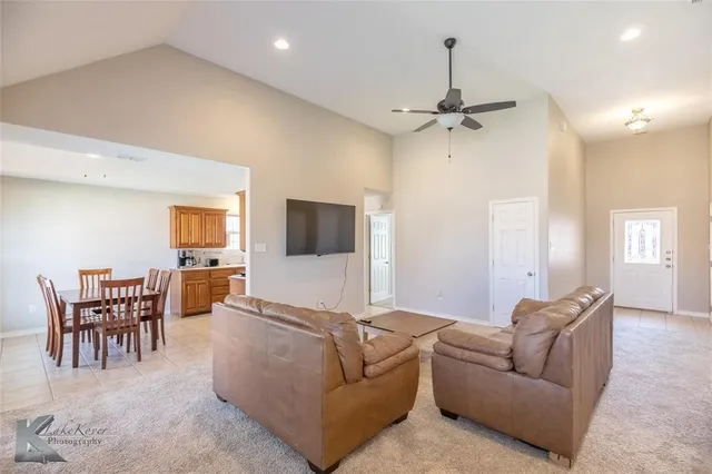 a living room with furniture a chandelier and a flat screen tv