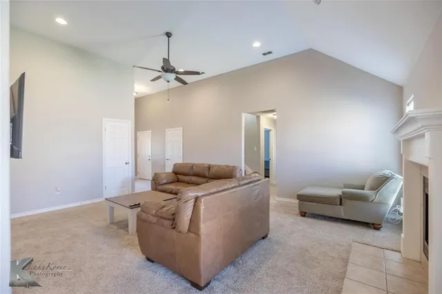 a living room with furniture and a ceiling fan