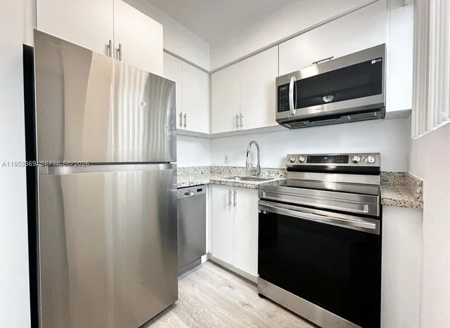 a kitchen with stainless steel appliances a refrigerator stove and microwave