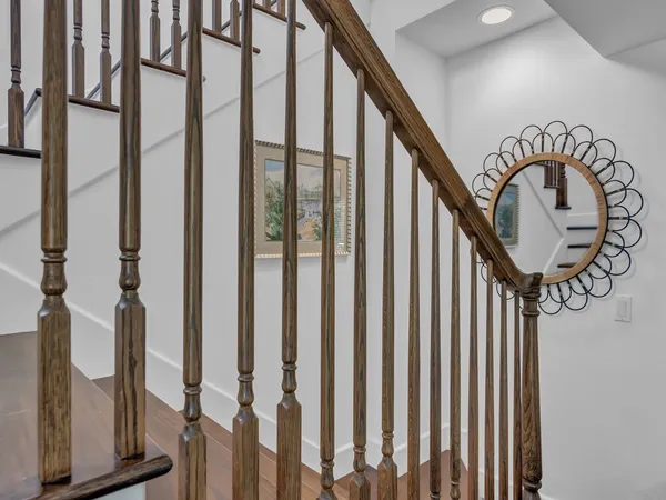 a view of staircase with railing and a chandelier