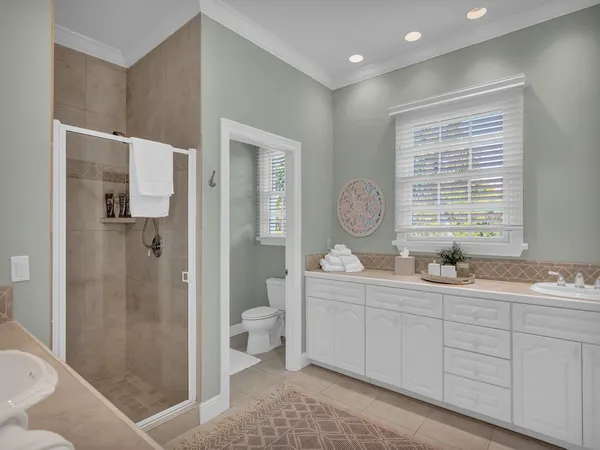 a bathroom with double vanity sink a mirror and a shower