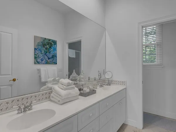 a bathroom with double vanity sinks and a mirror
