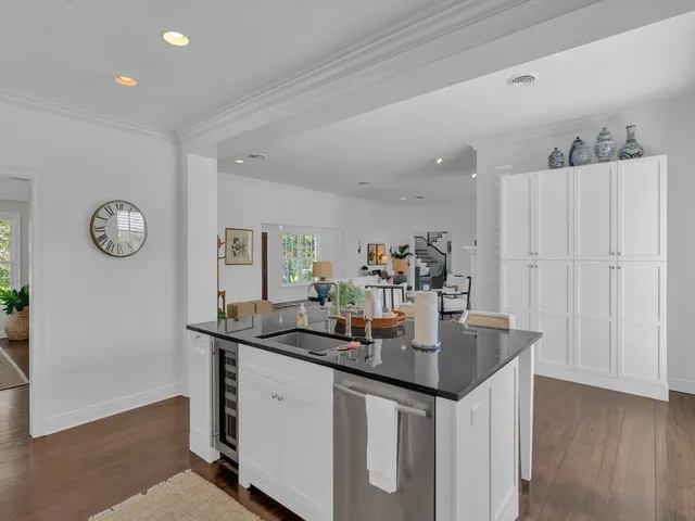 a kitchen with granite countertop a sink cabinets and wooden floor