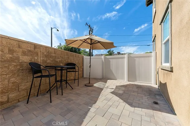 a patio with a table and chairs under an umbrella