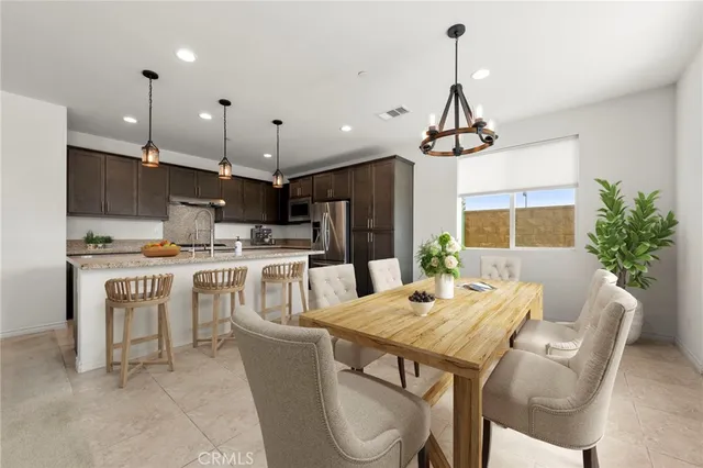 a kitchen with stainless steel appliances kitchen island granite countertop a kitchen island a stove a table and chairs