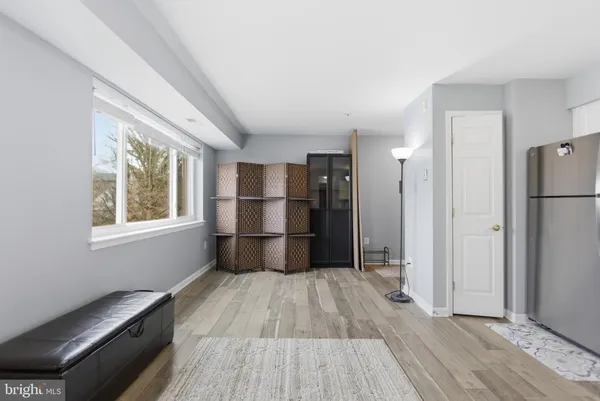 a kitchen with a refrigerator and wooden floor