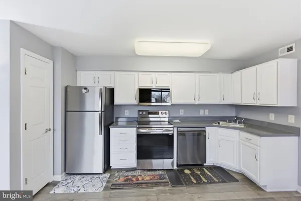 a kitchen with stainless steel appliances a stove a sink and a refrigerator