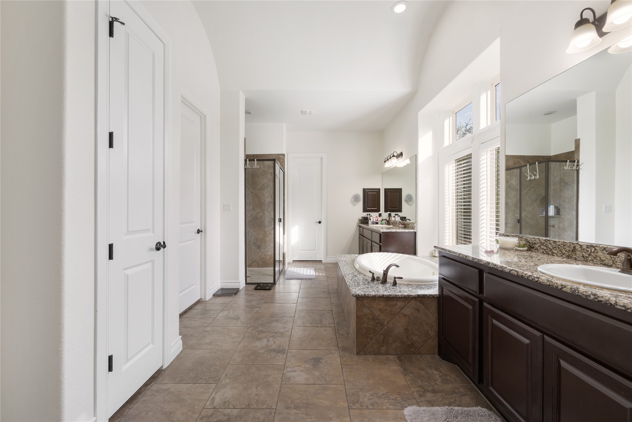 415 Bitterroot Lane Austin, TX 78737 - Photo 12 of 25 Luxurious primary bath with dual vanities, a deep soaking tub, and a spacious walk-in shower.