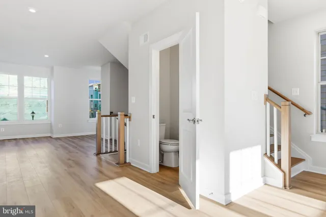 a view of a hallway with wooden floor and closet area