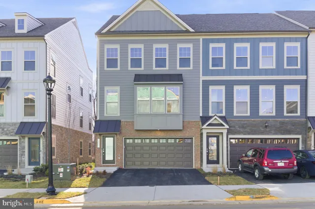 a front view of a building with a garden and plants
