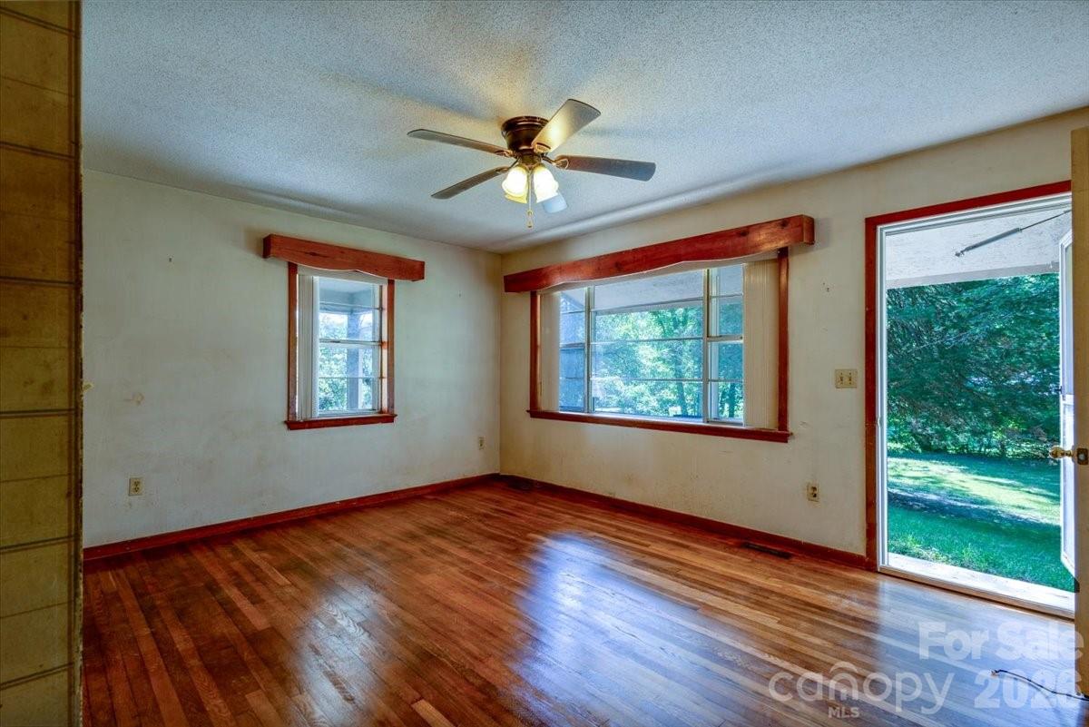 156 Old Sweetwater Road Robbinsville, NC 28771 - Photo 8 of 25 a view of an empty room with wooden floor and a window