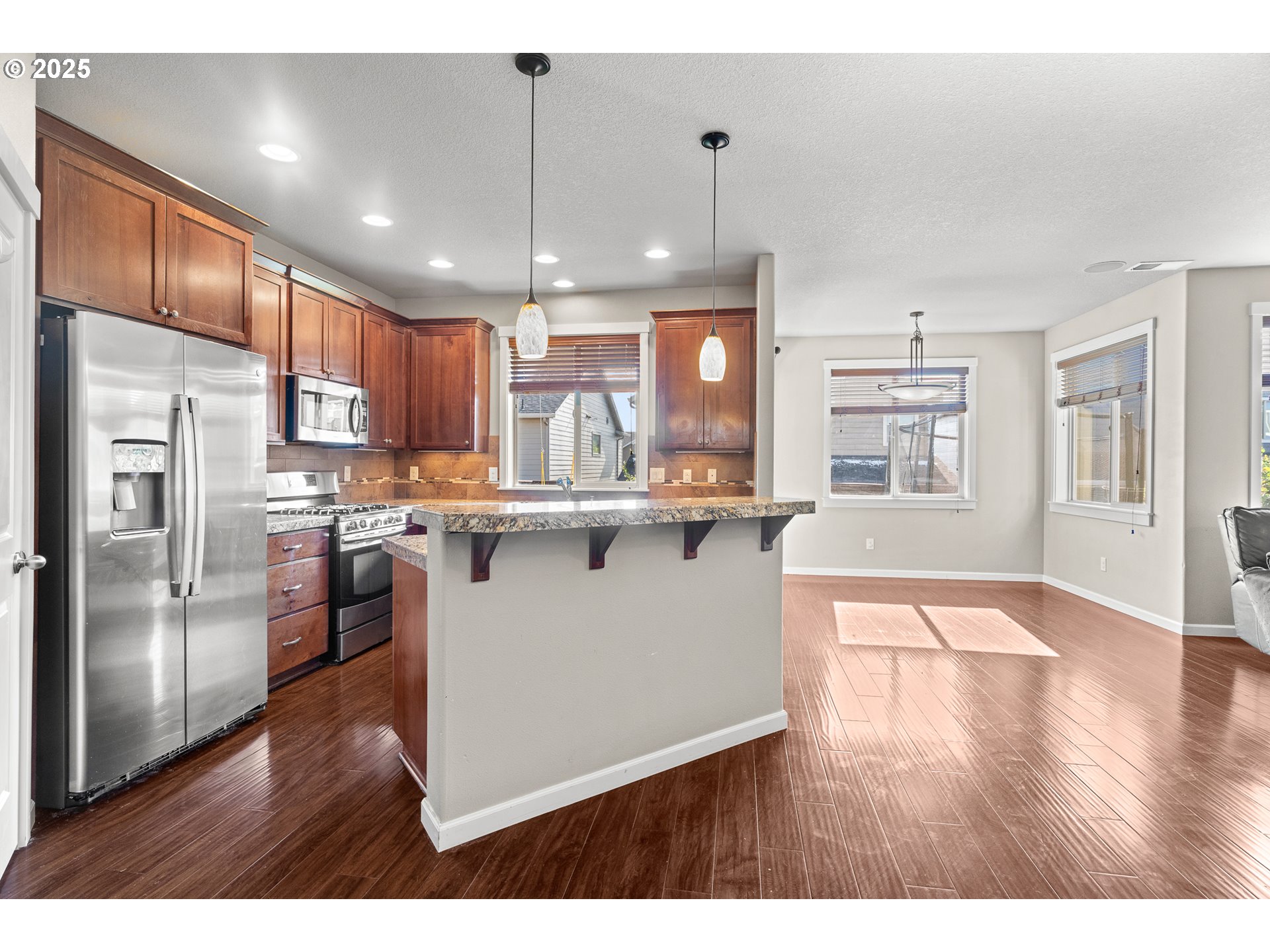 514 North 40th Avenue Ridgefield, WA 98642 - Photo 11 of 46 a kitchen with stainless steel appliances granite countertop a refrigerator a sink dishwasher a stove and white countertops with wooden floor