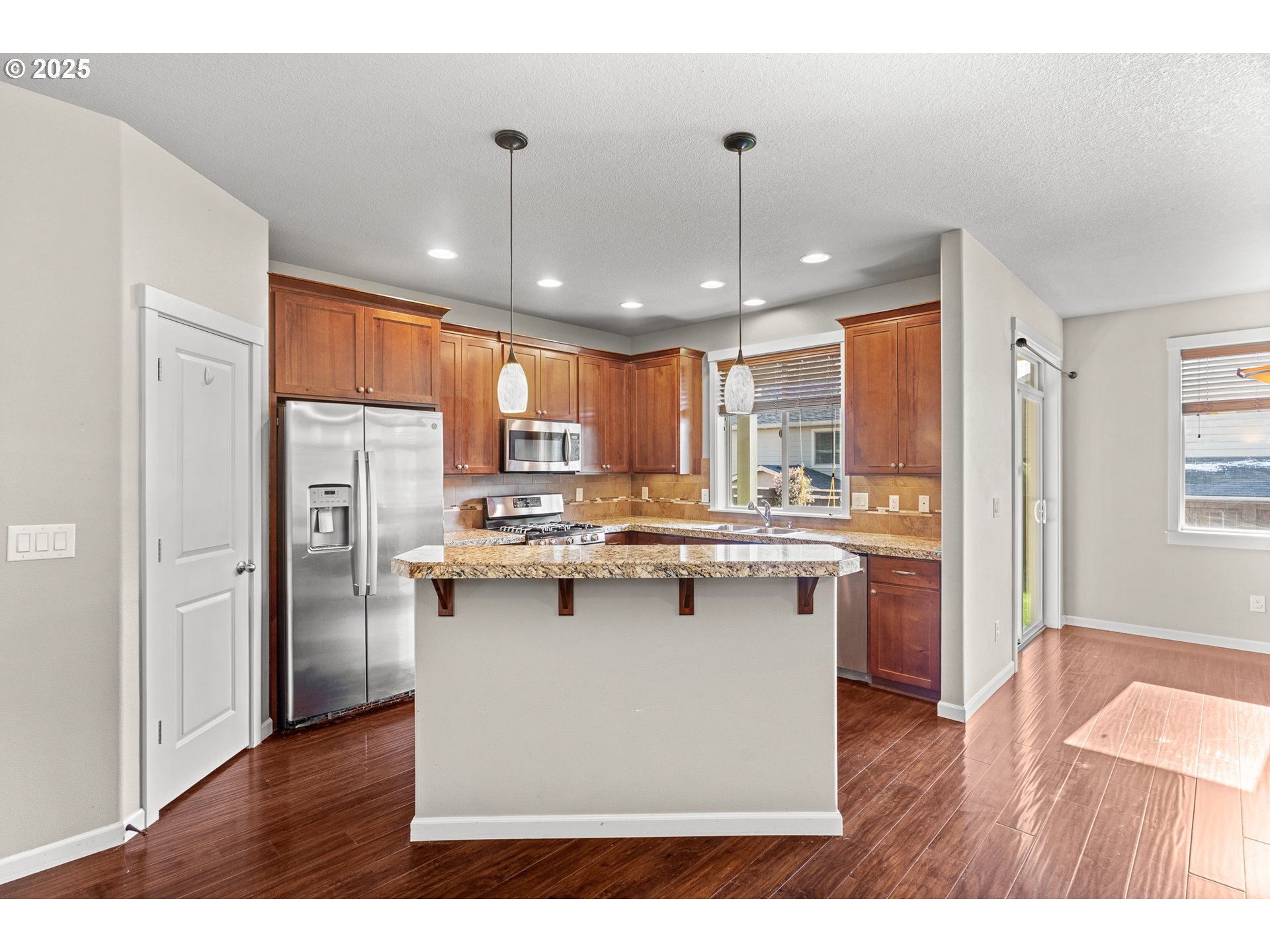 514 North 40th Avenue Ridgefield, WA 98642 - Photo 12 of 46 a kitchen with stainless steel appliances granite countertop a refrigerator a sink dishwasher a stove and white countertops with wooden floor