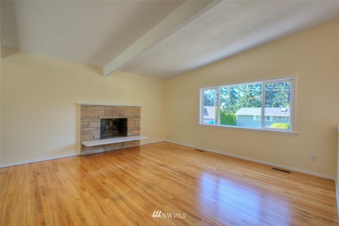 12402 Southeast 160th Street Renton, WA 98058 - Photo 3 of 21 a view of an empty room with wooden floor and a window