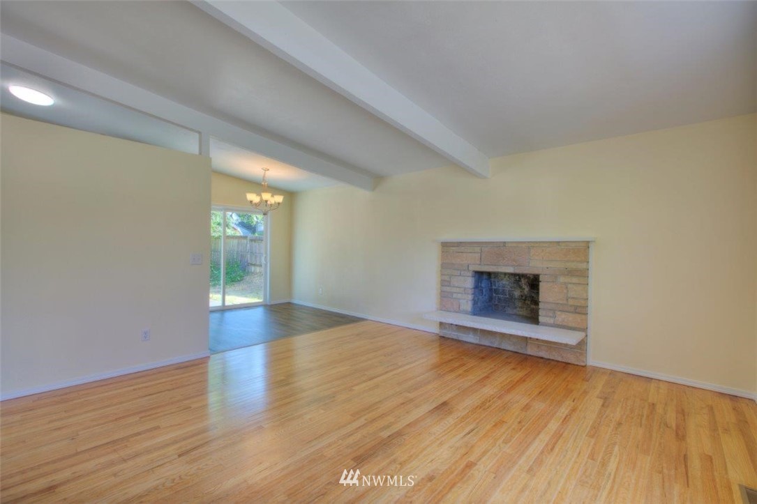 12402 Southeast 160th Street Renton, WA 98058 - Photo 5 of 21 an empty room with wooden floor and fireplace