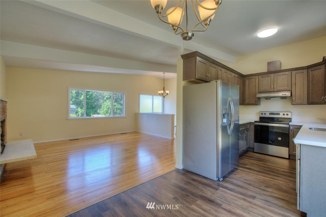 12402 Southeast 160th Street Renton, WA 98058 - Photo 8 of 21 a kitchen with stainless steel appliances a refrigerator stove and wooden floor