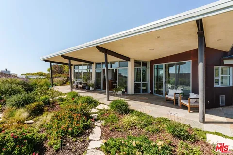 a view of a patio with table and chairs and potted plants
