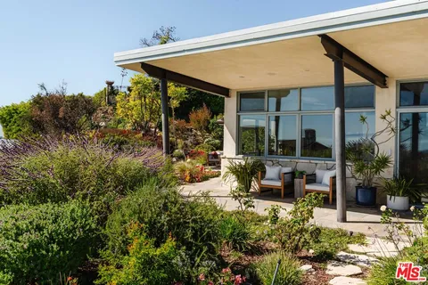 a view of a house with backyard sitting area and garden