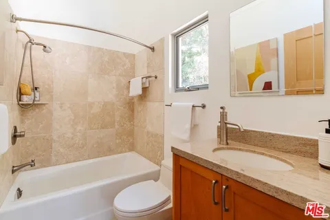 a living room with furniture large window and wooden floor