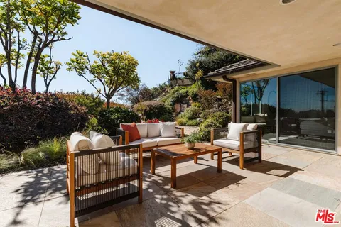 a building outdoor space with patio furniture and potted plants