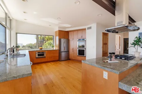 a kitchen with stainless steel appliances granite countertop sink stove and refrigerator