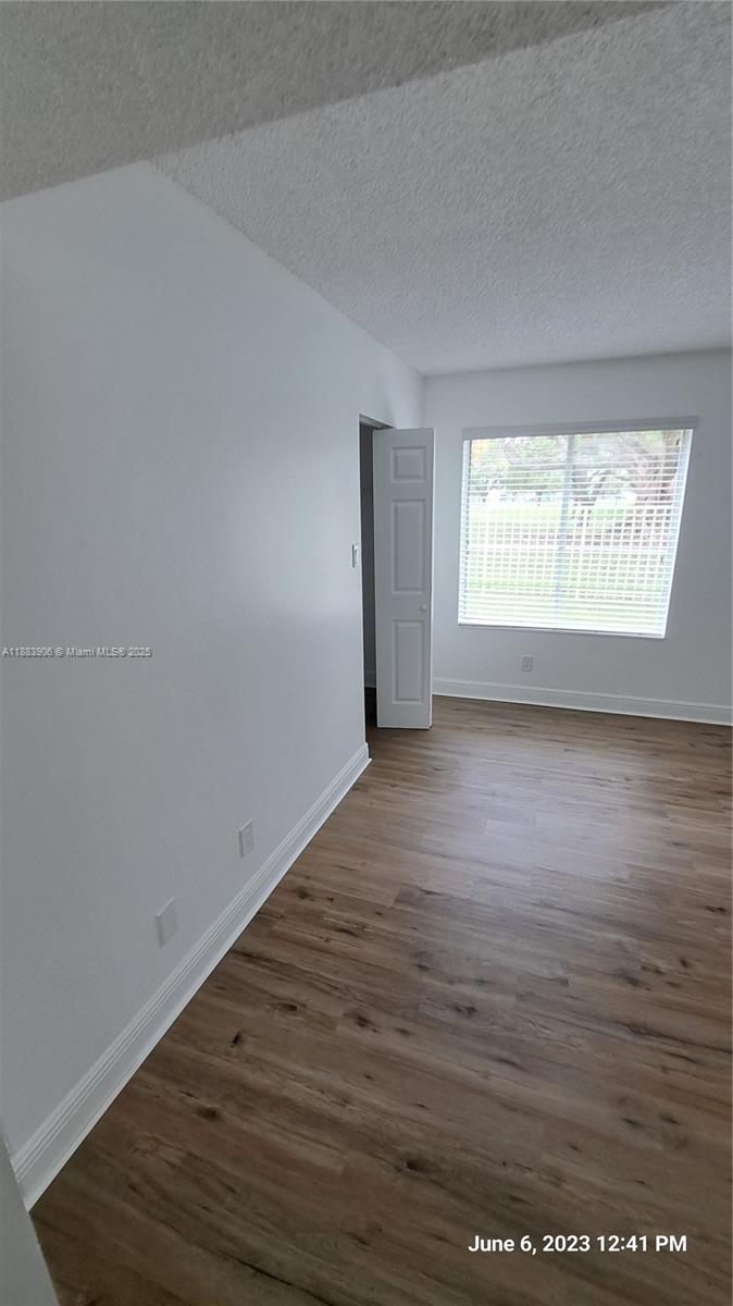 15770 Southwest 106th Terrace, Unit 104 Miami, FL 33196 - Photo 15 of 30 an empty room with wooden floor and windows