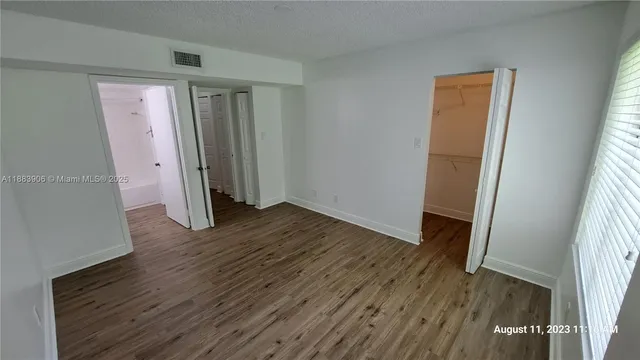 an empty room with wooden floor and a window