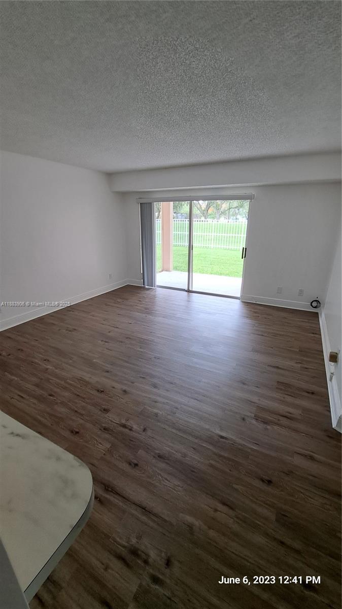 15770 Southwest 106th Terrace, Unit 104 Miami, FL 33196 - Photo 5 of 30 an empty room with wooden floor and windows