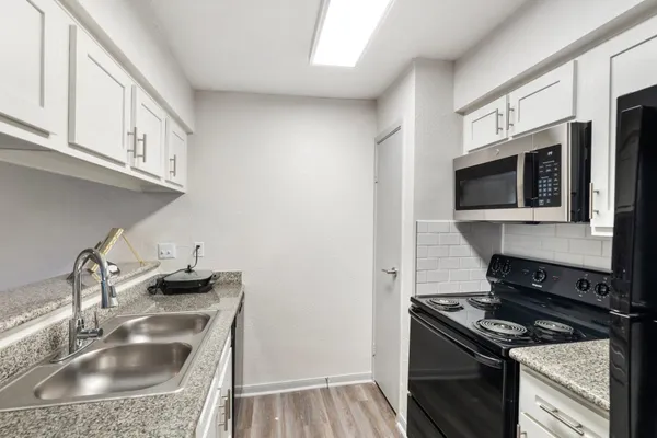 a kitchen with stainless steel appliances granite countertop a sink stove and microwave