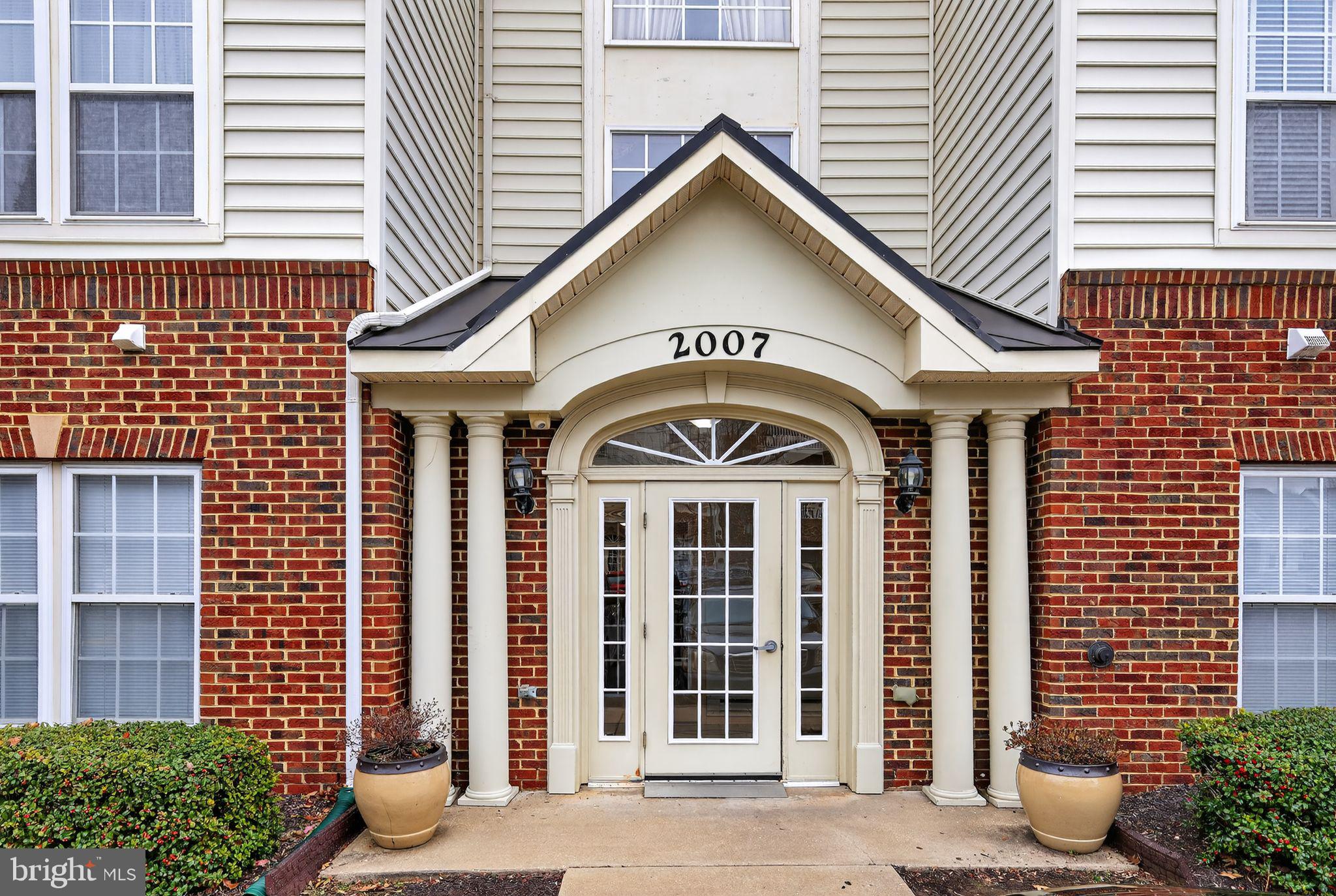 a view of a brick house with potted plants