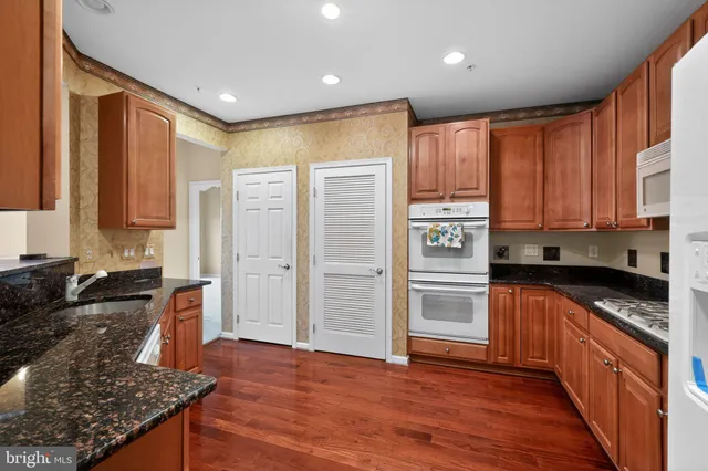 a kitchen with granite countertop wooden cabinets and a stove top oven