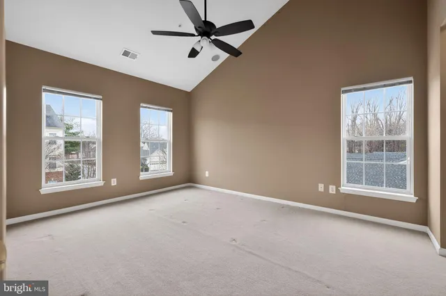 an empty room with windows and fan