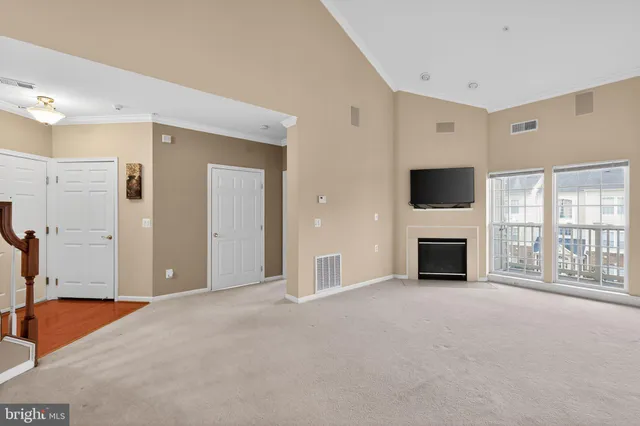 a view of an empty room with a fireplace and a window