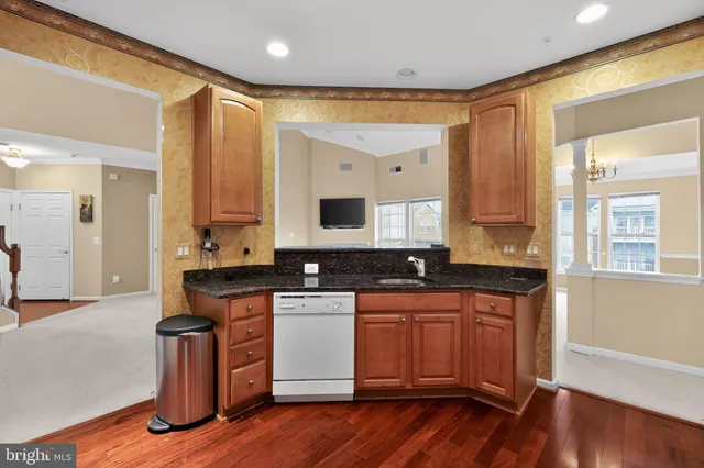 a kitchen with stainless steel appliances granite countertop wooden floors and white cabinets