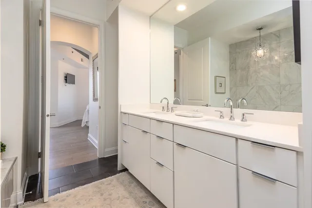 a bathroom with a double vanity sink a mirror and a shower