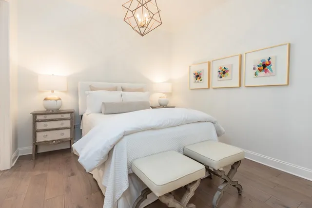 a bedroom with a bed and a chandelier