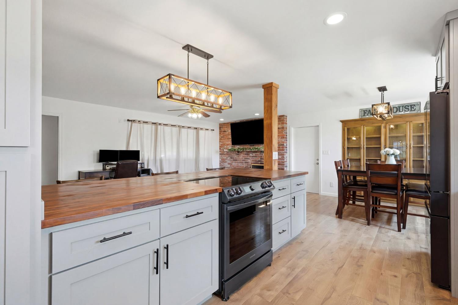 289 West Cypress Avenue Reedley, CA 93654 - Photo 17 of 45 a kitchen with granite countertop stainless steel appliances a stove top oven a sink a dining table and chairs with wooden floor