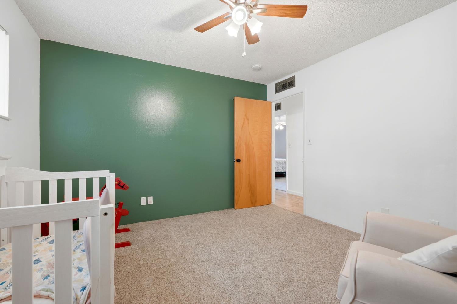 289 West Cypress Avenue Reedley, CA 93654 - Photo 25 of 45 a bedroom with a bed and a chandelier