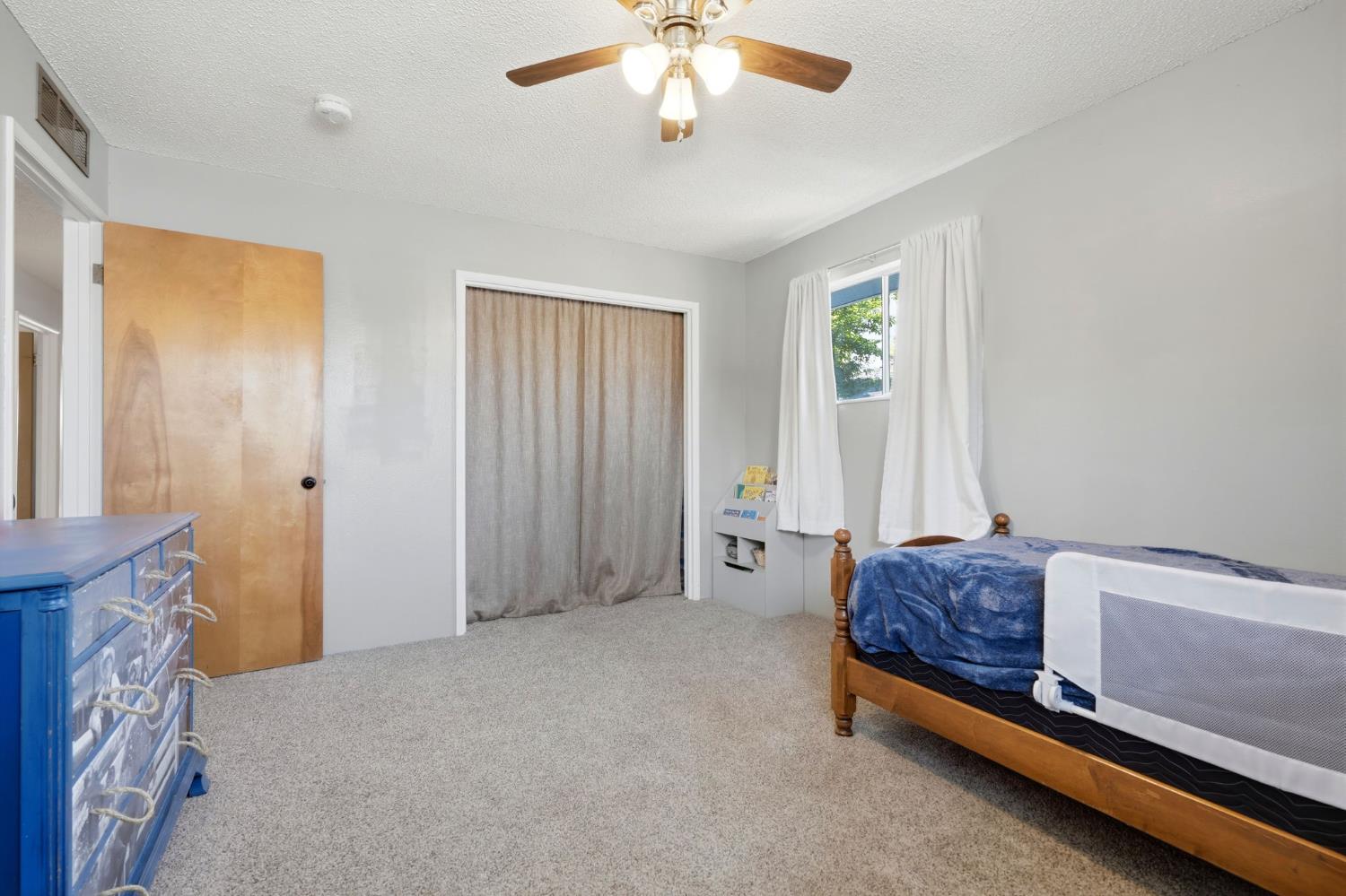 289 West Cypress Avenue Reedley, CA 93654 - Photo 27 of 45 a living room with a bed furniture and a window