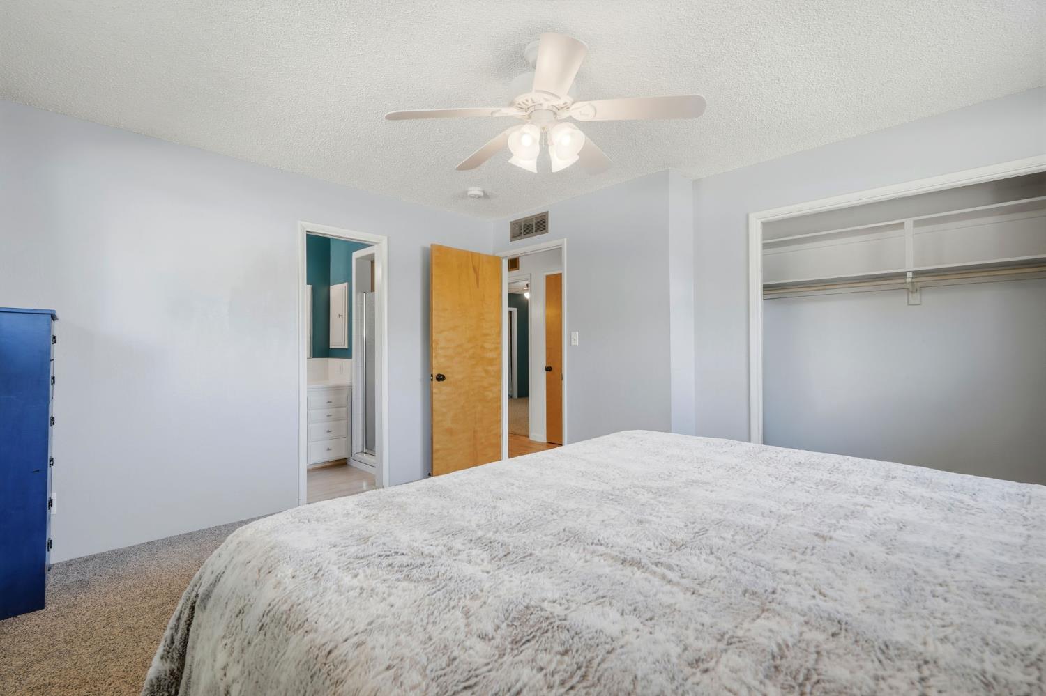 289 West Cypress Avenue Reedley, CA 93654 - Photo 30 of 45 a bedroom with a large bed closet and a chandelier