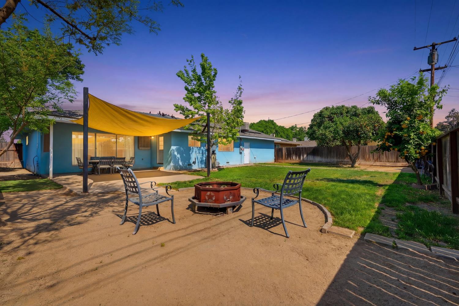 289 West Cypress Avenue Reedley, CA 93654 - Photo 38 of 45 a view of a patio with table and chairs potted plants and a palm tree